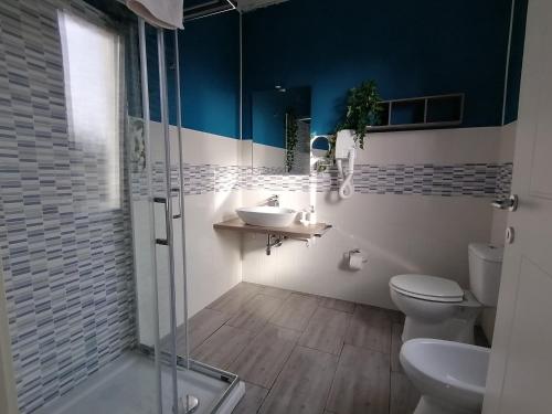 a bathroom with a toilet and a sink and a shower at Dimora Bed and Breakfast in San Gavino Monreale
