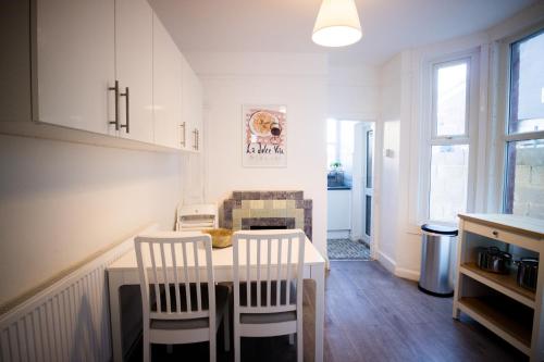 a kitchen with a table and chairs in a room at Dallow Rd Serviced Accommodation in Luton