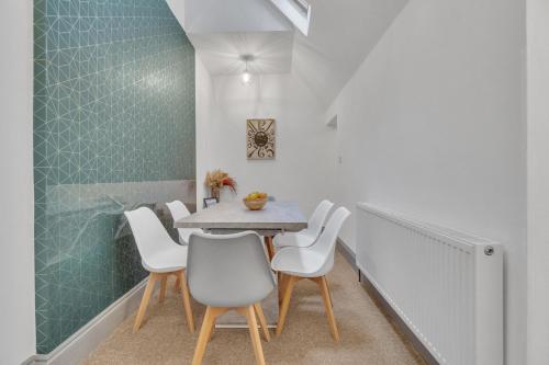 une salle à manger avec une table et des chaises blanches dans l'établissement Seaside Sanctuary House By My Getaways, à Brighton et Hove