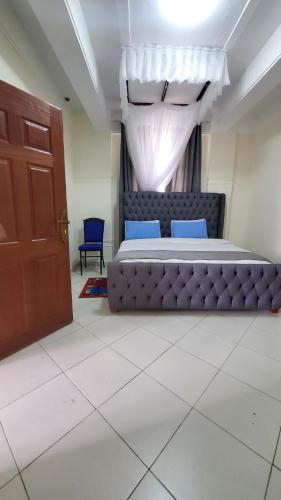 基塔萊的住宿－Le-voyage Resort Kitale，一间卧室设有一张大床和一扇门
