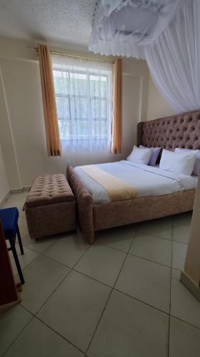 基塔萊的住宿－Le-voyage Resort Kitale，一间卧室设有一张大床和一个窗户。