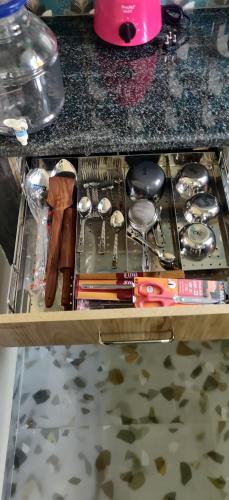 un tiroir rempli de nombreux outils sur un comptoir dans l'établissement Castle Hebbal Service Apartments, à Bangalore