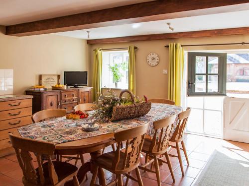a kitchen with a dining room table and chairs at The Hayloft- Dws in Marshwood