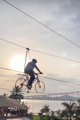 a man riding a bike on a utility wire at Divine Resort & Spa in Kampala