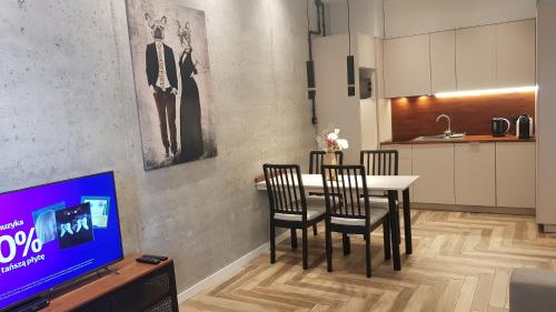 a dining room with a table and chairs and a tv at Active Residence C 408 in Lublin