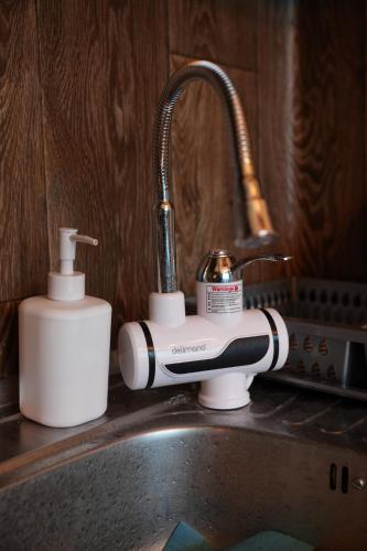 um lavatório de cozinha com um secador de cabelo e uma garrafa de sabão em Black Diamond em Niš