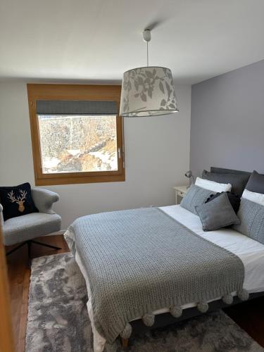 a bedroom with a bed and a chair and a window at Pineview Waldhaus in Flims