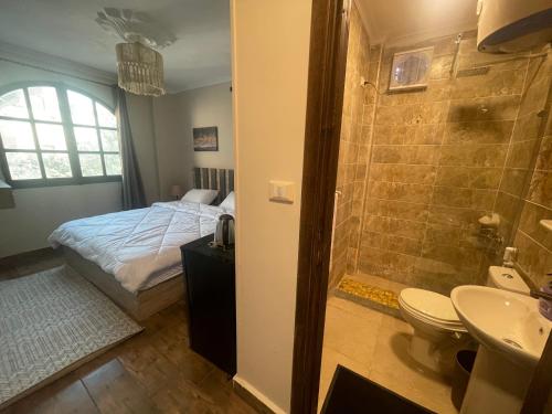 a bathroom with a bed and a shower and a sink at Malek Pyramids Guest House in Cairo