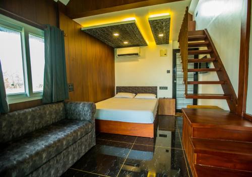 a bedroom with a bed and a couch and a staircase at JC Den Kochi Villas by VOYE HOMES in Cochin