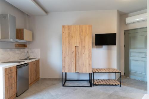 a kitchen with a large wooden cabinet with a sink at Olympus Pantheon Luxury Rooms in Plaka Litochorou