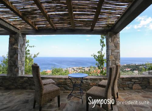 un patio con tavolo, sedie e vista sull'oceano di Pyrgos Traditional Village ad Agios Kirykos