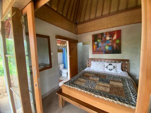 ein Schlafzimmer mit einem Bett in einem Zimmer in der Unterkunft Babahan Farmstay in Tabanan