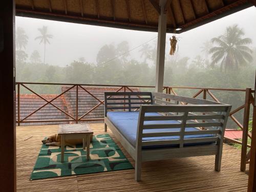 ein Schlafzimmer auf einer Terrasse mit einem Bett auf einem Balkon in der Unterkunft Babahan Farmstay in Tabanan