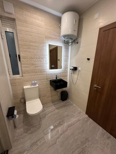 a bathroom with a toilet and a sink at La Bella Guesthouse in St Julian's
