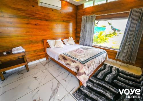 a bedroom with wooden walls and a bed with a window at JC Den Kochi Villas by VOYE HOMES in Cochin