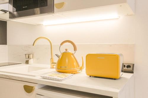 une bouilloire à thé jaune et un grille-pain sur un comptoir de cuisine dans l'établissement Blackwood-parking privé gratuit, à Villeurbanne