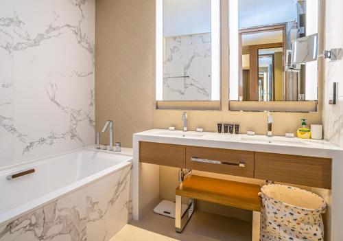 La salle de bains est pourvue d'une baignoire, d'un lavabo et d'une baignoire. dans l'établissement Vacay Lettings Luxury Living Address Opera Downtown, à Dubaï