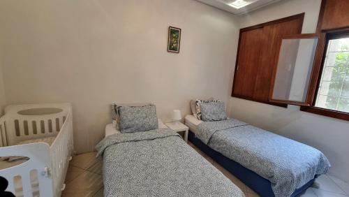 a room with two beds and a window at Wide Family Apartment in the new Center of Casablanca in Casablanca