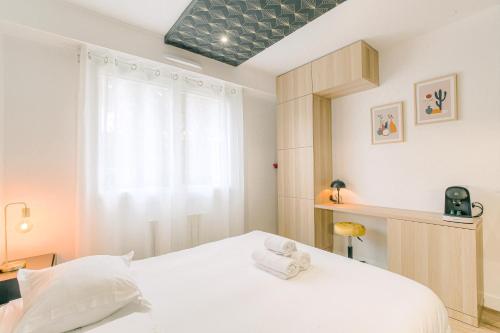 ein Schlafzimmer mit einem weißen Bett und einem Fenster in der Unterkunft Blackwood-parking privé gratuit in Villeurbanne
