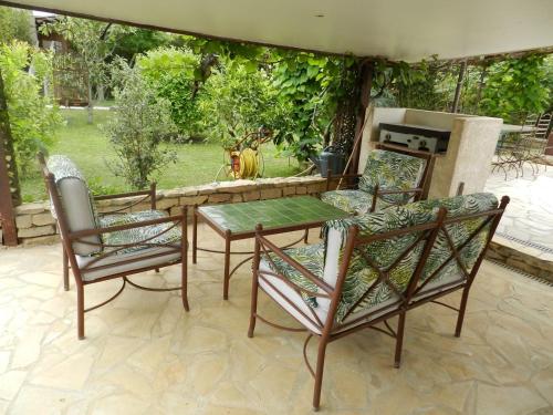a patio with a table and chairs and a dog at La villa les parfums d’Ete in Ornaisons