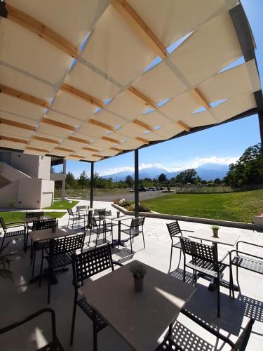 a patio with tables and chairs with a view of a field at Olympus Pantheon Luxury Rooms in Plaka Litochorou