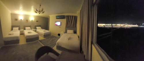 a hotel room with three beds and a window at GEM view BOUTIQUE in Cairo