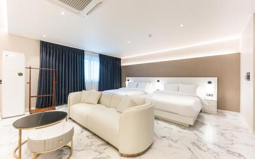 a bedroom with a large bed and a white couch at H Avenue Gyeongju Bulkuk temple in Gyeongju