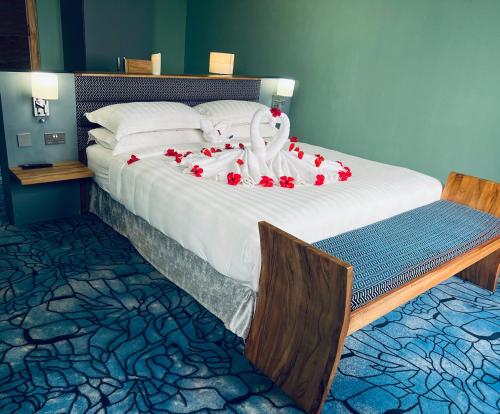 ein großes Bett mit roten Rosen darauf in der Unterkunft Aquarius Kigo Resort in Kigo