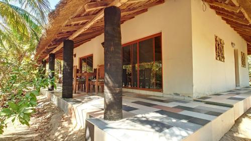 a house with a porch with columns and a patio at Très agréable maison 2 chambres avec jardin in Abene
