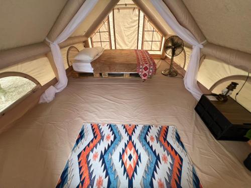 an attic room with a bed and a window at De Kampung Campsite in Rawang
