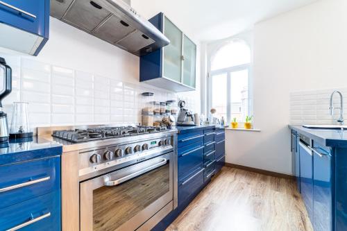 - une cuisine avec des placards bleus et une cuisinière dans l'établissement Design & confort 6 pers Hypercentre Dunkerque, à Dunkerque