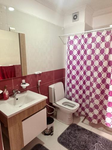 y baño con lavabo, aseo y cortina de ducha. en Appartement à beni mellal, en Beni Mellal