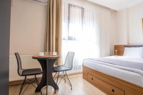 ein Hotelzimmer mit einem Bett, einem Tisch und Stühlen in der Unterkunft Campus Butik Hotel in Avcılar