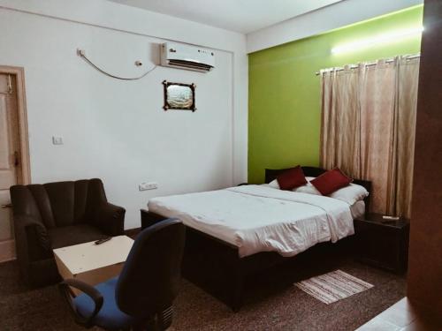 een kleine slaapkamer met een bed en een stoel bij Urban Express G Grand in Bangalore