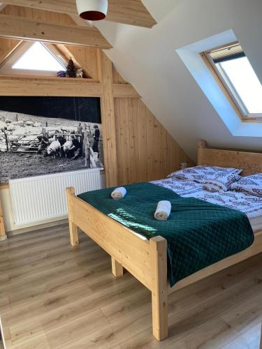 a bedroom with a bed with a green comforter at Apartament Nasze Poddasze in Ciche