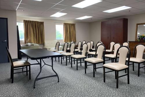 una habitación con una fila de sillas y una mesa en Ramada by Wyndham Bolingbrook, en Bolingbrook