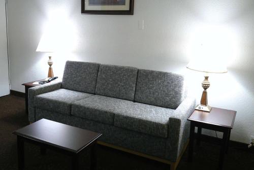 a living room with a couch and two tables with lamps at Wyndham Garden Detroit Metro Airport in Romulus