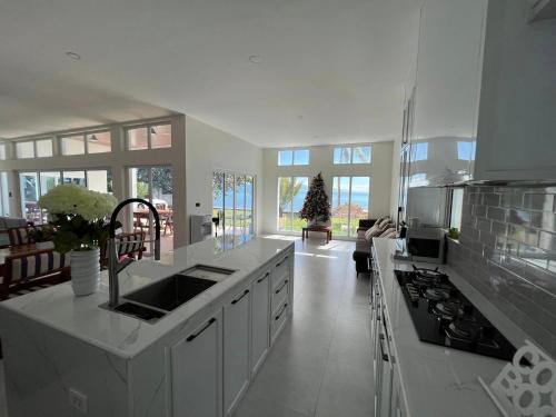 eine weiße Küche mit einer Spüle und einem Herd in der Unterkunft Sand Castle Villa - Classic Beachfont Luxury 