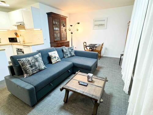 un salon avec un canapé bleu et une table basse dans l'établissement Appart sérénité au Pont de Joinville, Paris, à Joinville-le-Pont