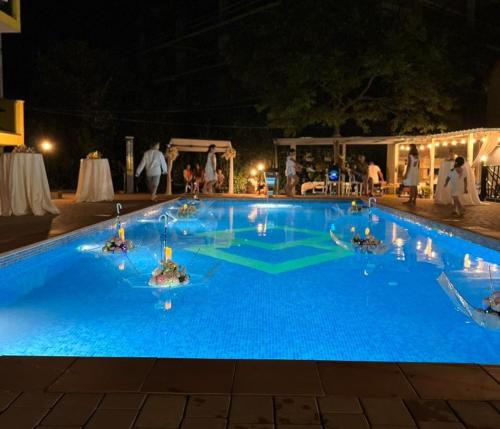 a large blue swimming pool at night with people at Casa Del Mar in Kvariati
