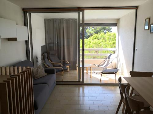 a living room with a couch and a sliding glass door at Studio calme à Giens , 2 pas du port et des plages in Hyères