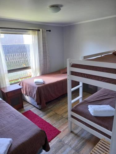a bedroom with two bunk beds and a window at Aysen Bike Cabañas in Puerto Aisén