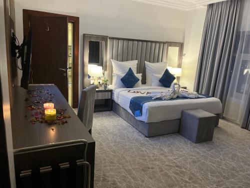 a hotel room with a bed and a table at فندق كارم in Raḩīmah
