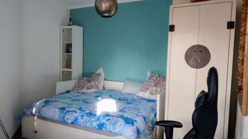 ein Schlafzimmer mit einem Bett mit einer blauen Wand in der Unterkunft Atico Soleado in Esplugues de Llobregat