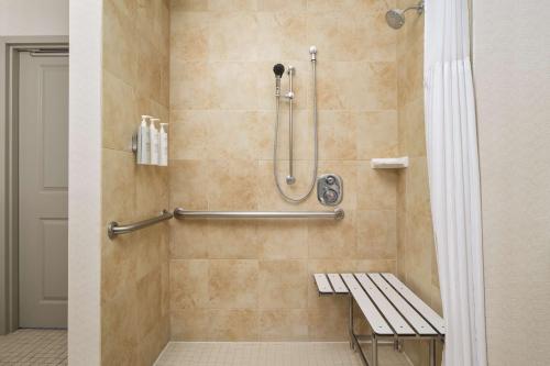 a shower with a bench in a bathroom at Hilton Garden Inn El Paso Airport in El Paso