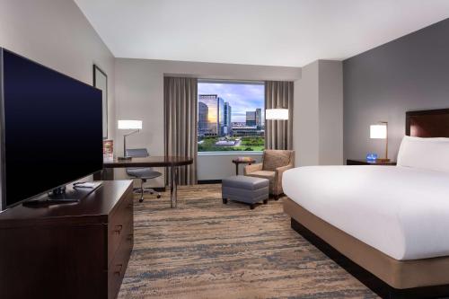 a hotel room with a bed and a flat screen tv at Hilton Americas - Houston in Houston