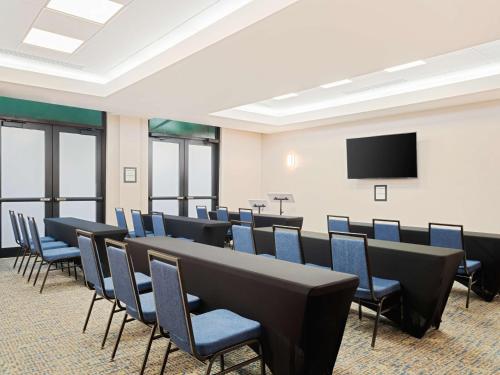 a conference room with chairs and a flat screen tv at Hampton Inn West Palm Beach-Florida Turnpike in West Palm Beach