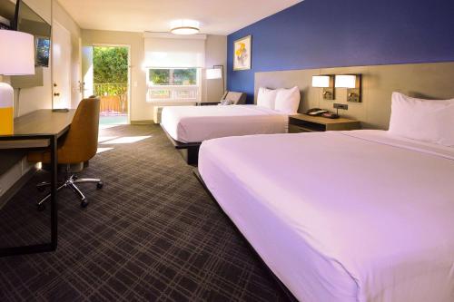 a hotel room with two beds and a desk at Comfort Inn Encinitas Near Legoland in Encinitas