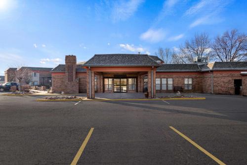an empty parking lot in front of a brick building at Suburban Studios Kansas City Airport North in Platte City