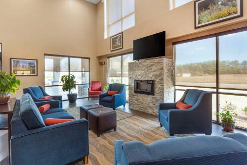 a living room with couches and a fireplace at Comfort Suites Wilson - I - 95 in Wilson